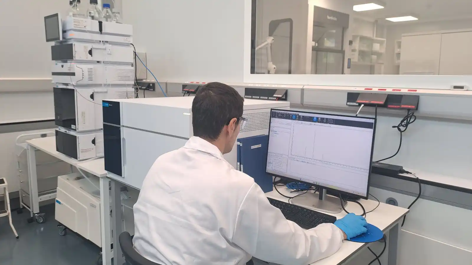 Analista revisando datos de cromatografía en un laboratorio analítico certificado GMP